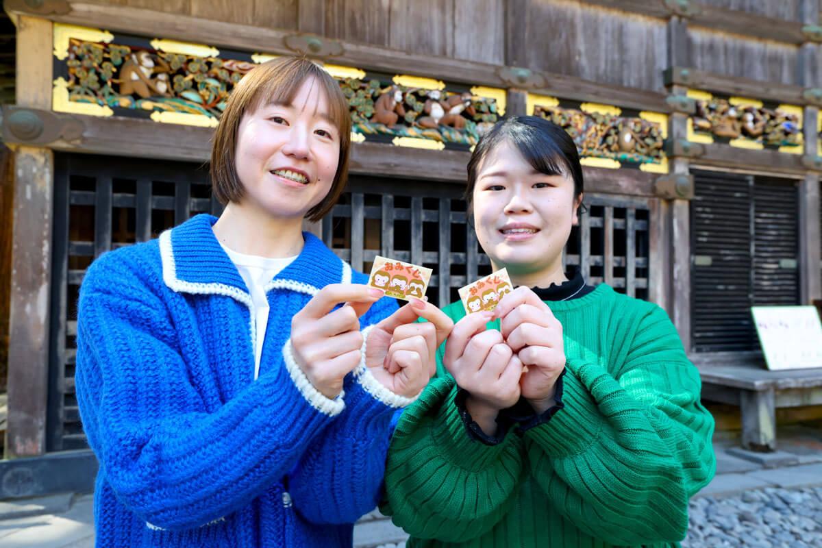 三猿おみくじを持つスタッフ