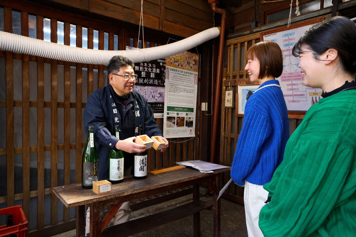 渡邉佐平商店で日本酒について説明を受けるスタッフ